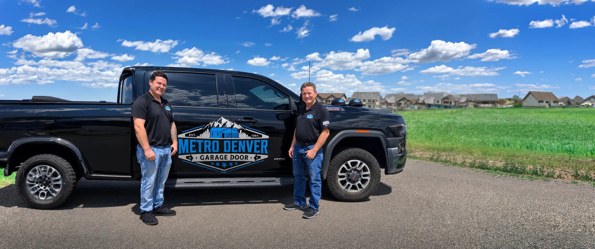 Randy Krouse and his son standing beside the Metro Denver Garage Door service truck
