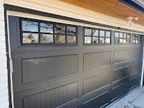 Dark grey garage door with a row of inset windows