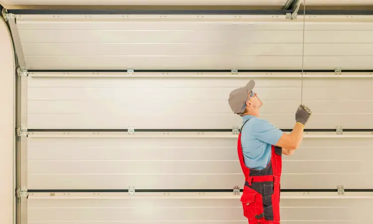 A professional garage door technician on an installation job.